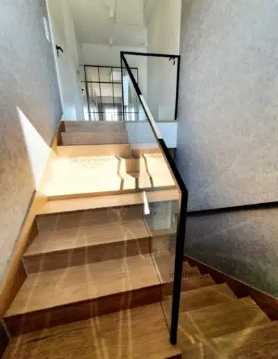 Designerska balustrada szklana z czarnym pochwytem i drewnianymi schodami, perspektywa w Wejherowie.